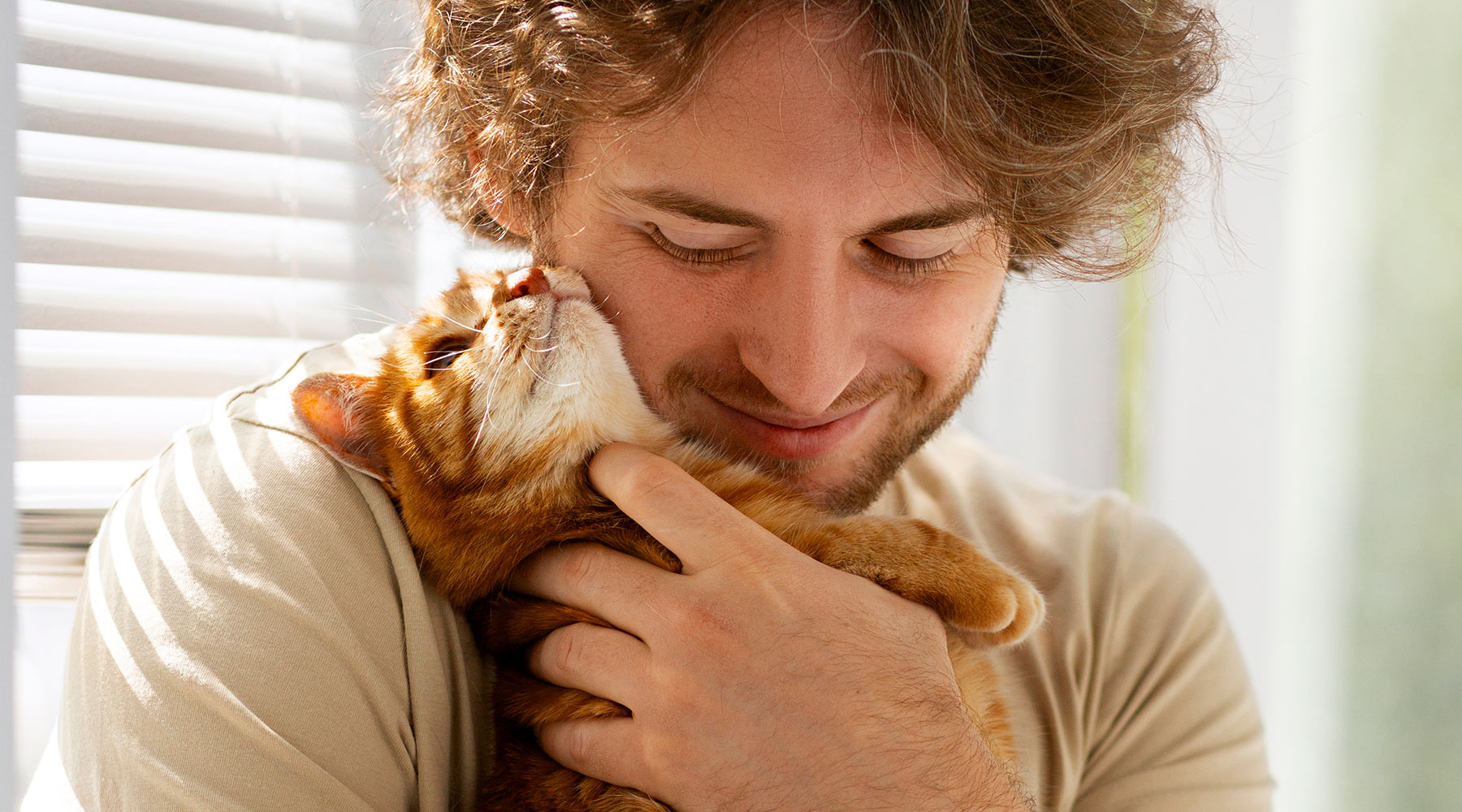 smiling-man-holding-orange-cat-1800x1000-1